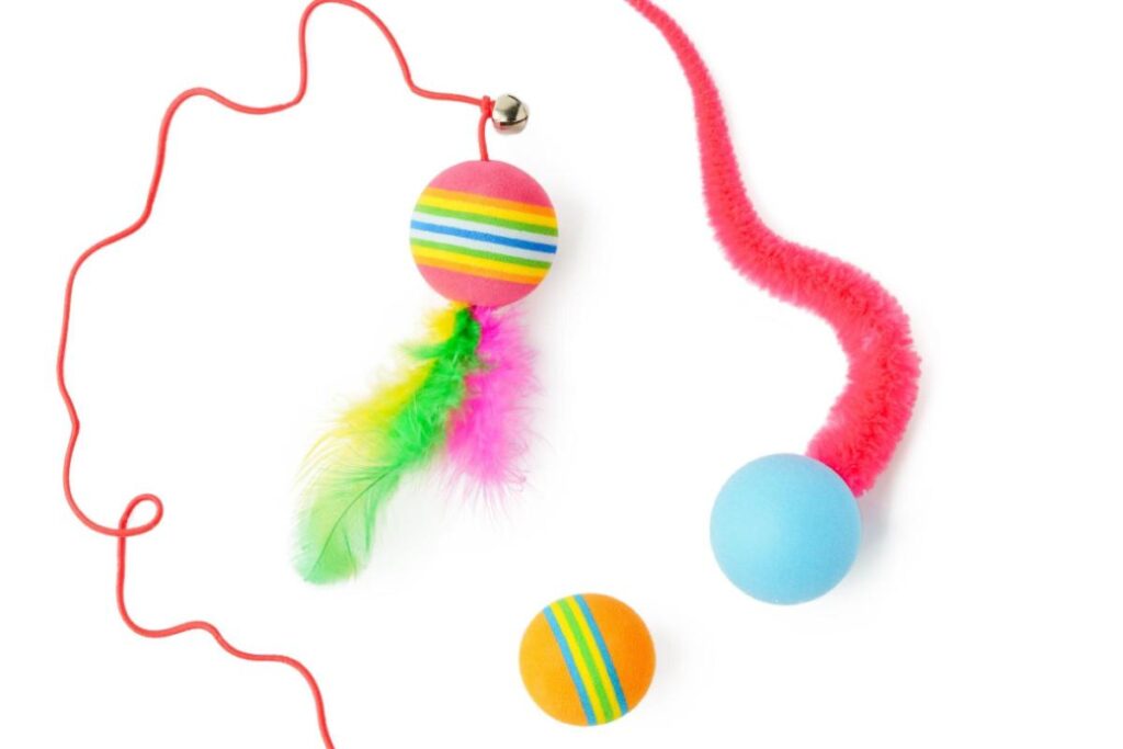 Brinquedos coloridos com penas e pompom