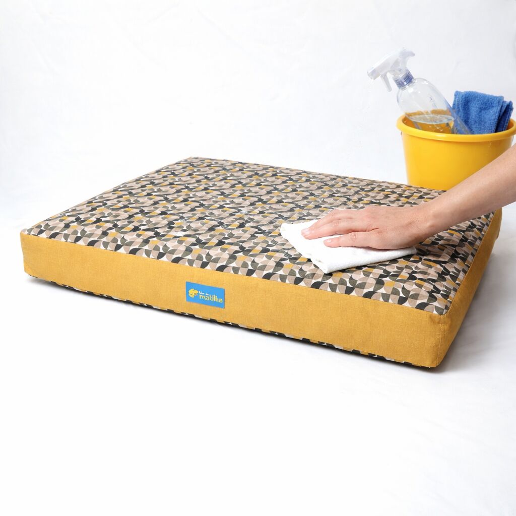 Almofada sendo limpa com pano úmido